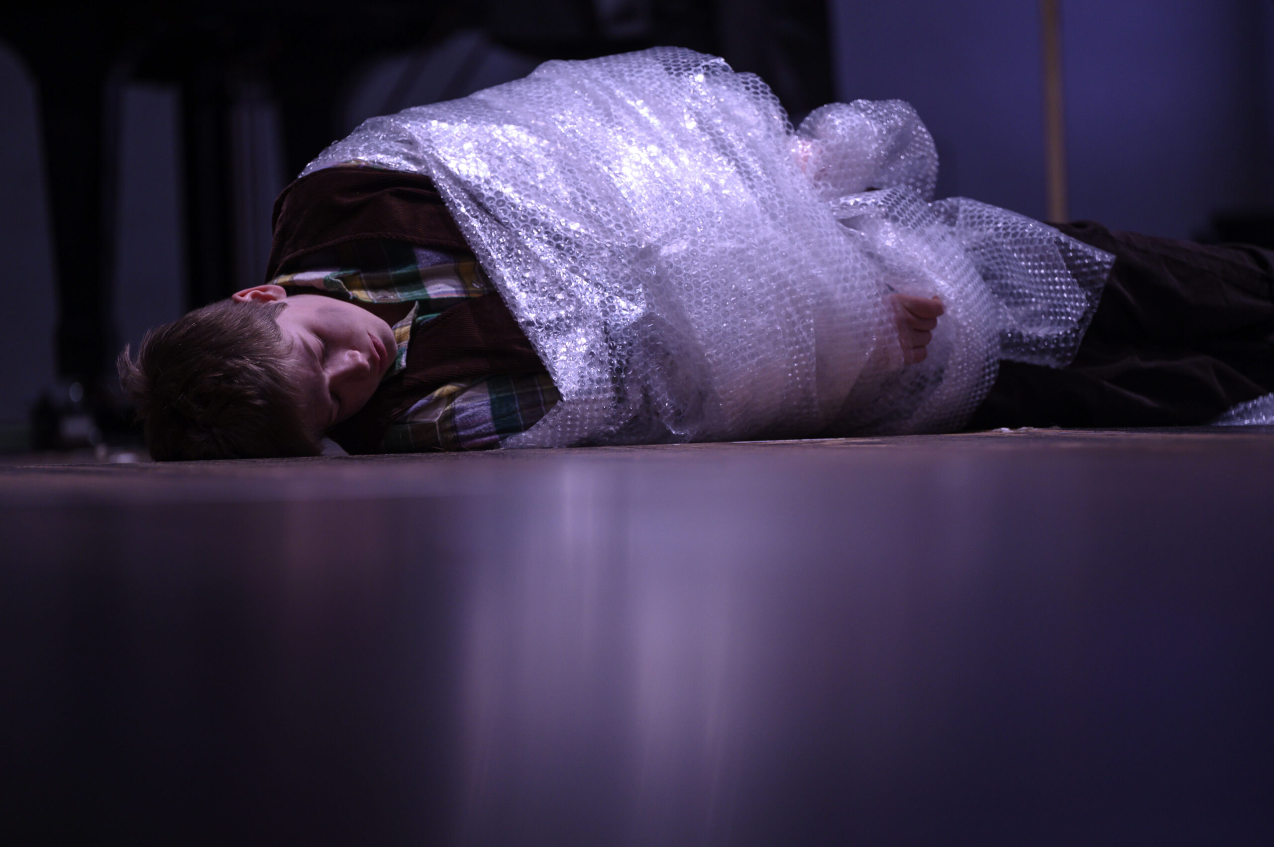 Kind umwickelt mit Luftpolster-Folie